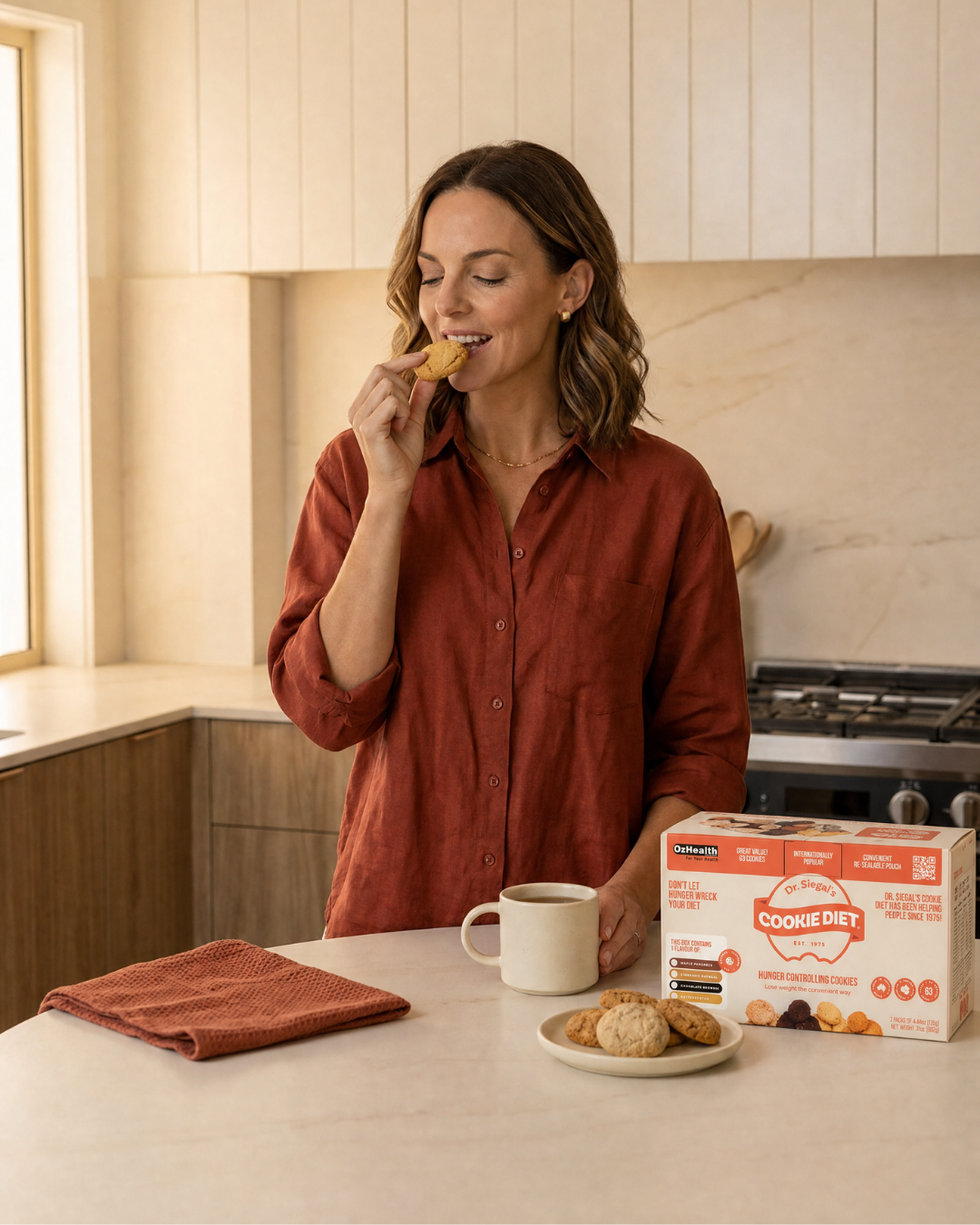 Woman enjoying a Cookie Diet biscuit in a kitchen